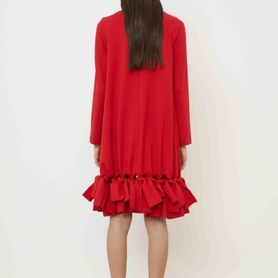 Vestido vermelho com laços na barra, visto de costas, usado com sandálias pretas