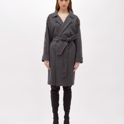 Mulher a vestir casaco cinzento com cinto e botas pretas até ao joelho