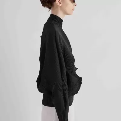 Mulher de perfil a usar camisola preta texturizada com gola alta e óculos escuros