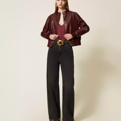 Mulher com casaco de pele castanha, blusa vermelha, calças de ganga pretas e cinto preto