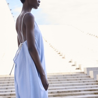 Vestido azul claro leve com alças finas brancas e decote nas costas