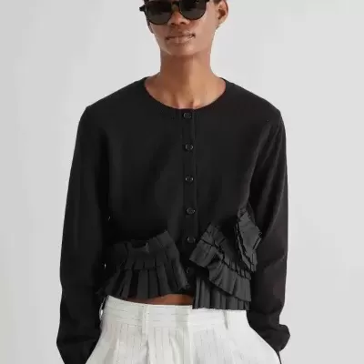 Cardigan preto com botões e folhos, calças brancas riscas finas verticais