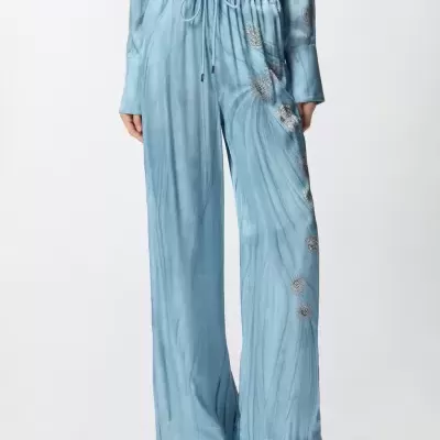 Calças largas azul claro com bordados florais prateados e cós elástico