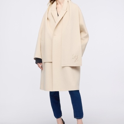 Mulher a usar casaco bege oversized com lenço 