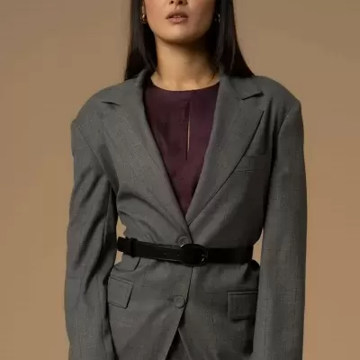 Pessoa com fato cinzento risca de giz e cinto preto