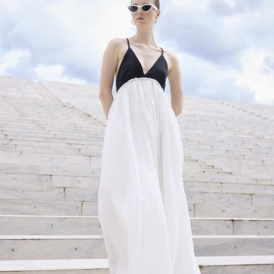 Vestido longo preto e branco com óculos de sol brancos em escadas de pedra