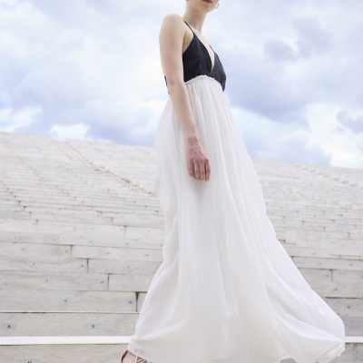 Vestido longo preto e branco com sandálias brancas em escadas de pedra numeradas