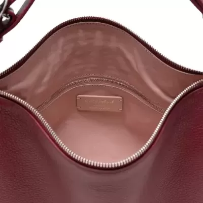 Mala castanha com interior rosa e etiqueta COCCINELLE