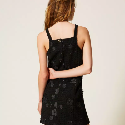 Vestido preto curto com padrão floral texturizado e alças largas visto de costas