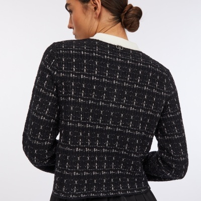 Casaco feminino preto xadrez com gola branca visto de costas.