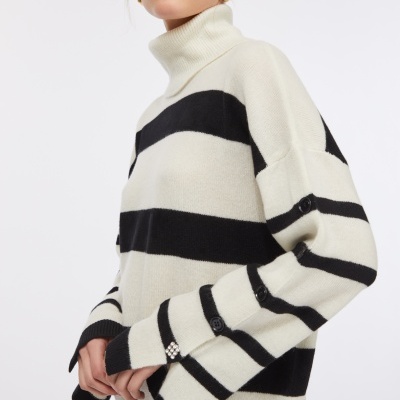 Camisola de gola alta creme e preta com riscas horizontais e botões nas mangas