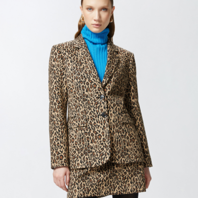 Mulher vestindo conjunto com blazer e saia animal print e camisola azul