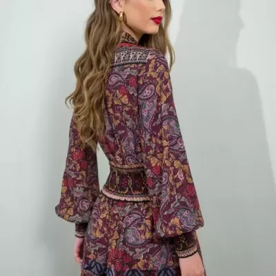 Vestido comprido com padrão floral e folhagem em tons de vinho e castanho visto de costas