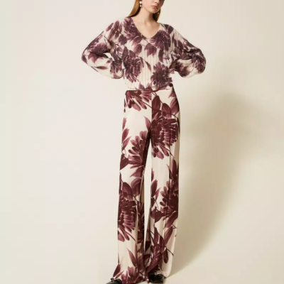 mulher a usar conjunto floral castanho e branco com calças largas