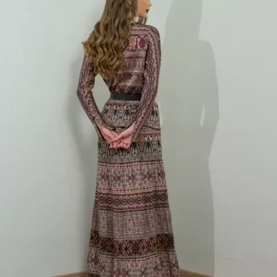 Mulher de costas usando vestido comprido com padrão étnico colorido