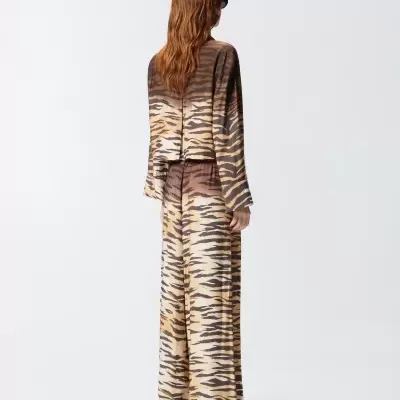 Conjunto de pijama com padrão tigresa castanho, bege e preto visto de costas