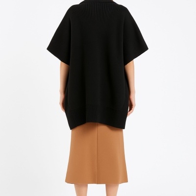 Mulher de costas com capa preta e saia midi camel