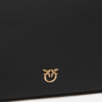 Detalhe de mala preta com logotipo dourado de aves