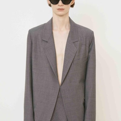 Blazer cinzento junto com saia da mesma cor usada por modelo