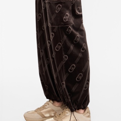 Calças aveludadas castanhas com padrão e tênis bege com sola grossa