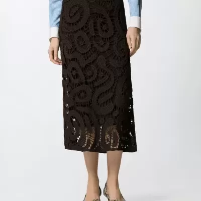 Saia midi preta em crochê com padrão espiral, camisa azul às riscas, sapatos salto baixo com padrão pele cobra