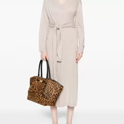 Vestido bege com nó e mala padrão leopardo com alças pretas