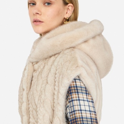 Casaco creme de pelo sintético com capuz sobre camisa xadrez azul, bege e branca
