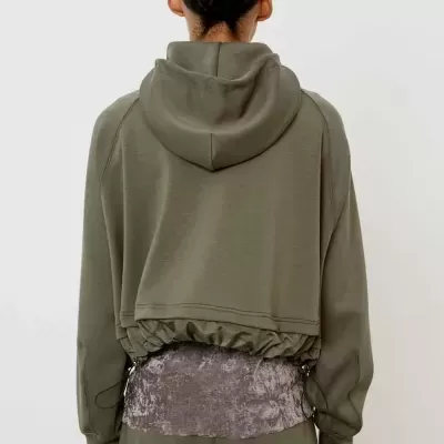 Pessoa de costas com casaco verde-oliva e top cinza texturizado