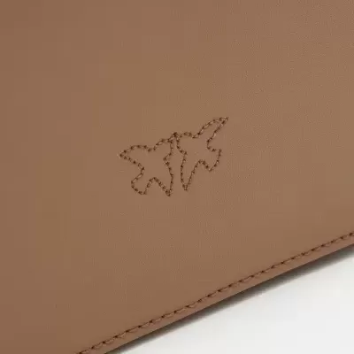 Artigo em pele castanha clara com bordado de aviões e costura reforçada