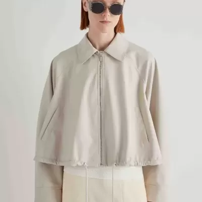 Casaco cropped bege claro com fecho de correr e bolsos laterais