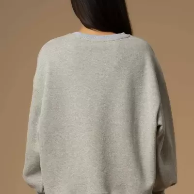 Pessoa vista pelas costas usando sweat cinzenta clara e calças bordô