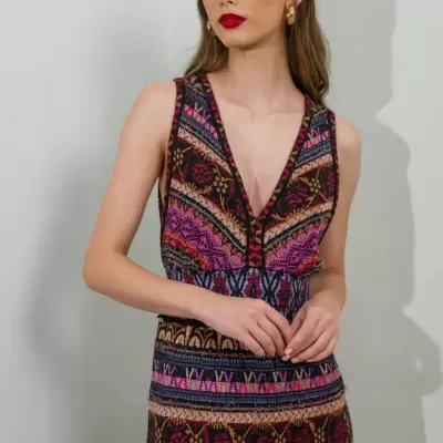 Modelo veste vestido étnico colorido com decote em V e brincos dourados