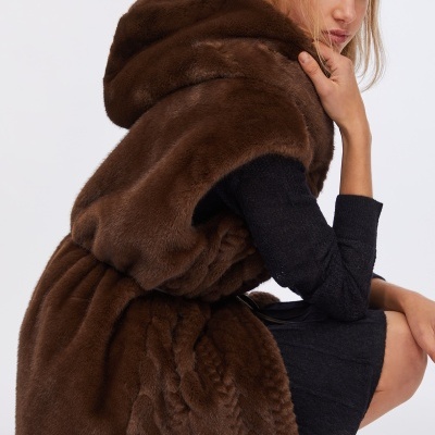 Casaco de pêlo castanho escuro com capuz e vestido preto em fundo branco