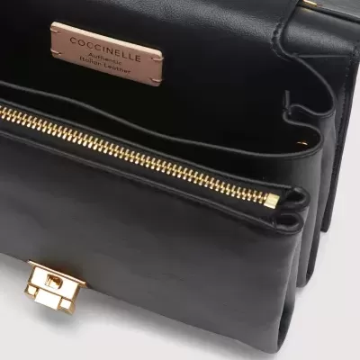 Carteira preta de pele autêntica italiana COCCINELLE com fecho dourado e interior dividido.