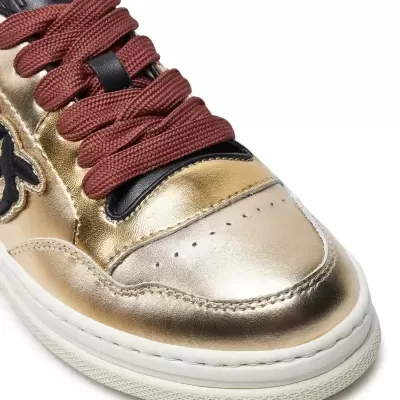 Tênis dourado metálico com atacadores castanho-escuro e sola branca