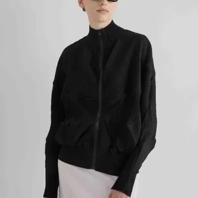 Mulher com sweatshirt preta texturizada e saia branca translúcida