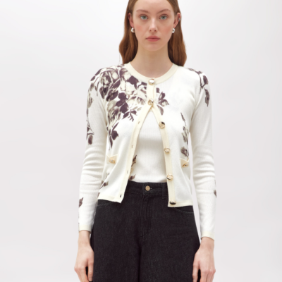 Cardigan branco com flores castanhas, botões dourados, sobre top branco e calças pretas largas