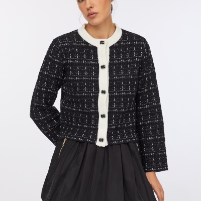 Blusão feminino preto de tweed com botões e saia preta plissada