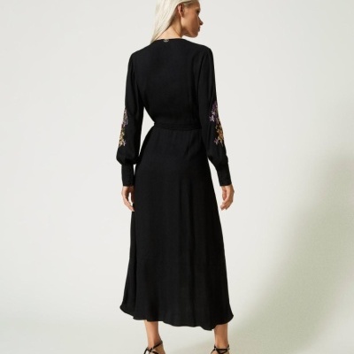 Vestido preto comprido com bordados nas mangas visto de costas