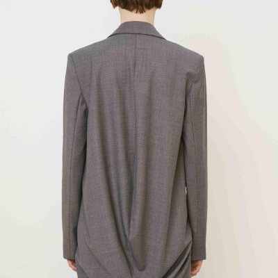 Blazer cinza liso com corte alongado e drapeado atrás