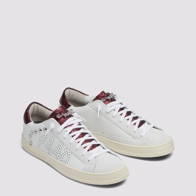 Ténis brancos de pele com detalhes vermelhos metálicos e atacadores brancos com linhas vermelhas