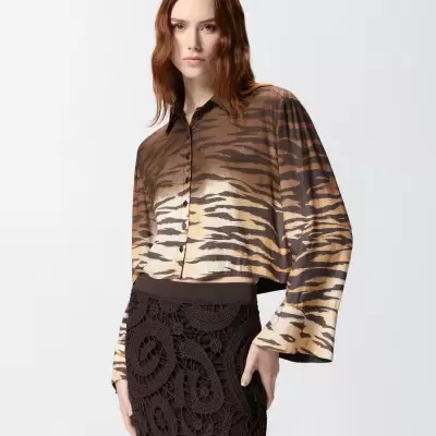 Camisa feminina com padrão animal print castanho e saia preta de croché