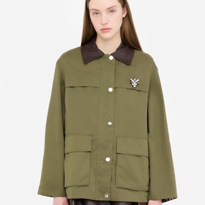 Casaco verde-oliva com botões e broche em modelo feminino