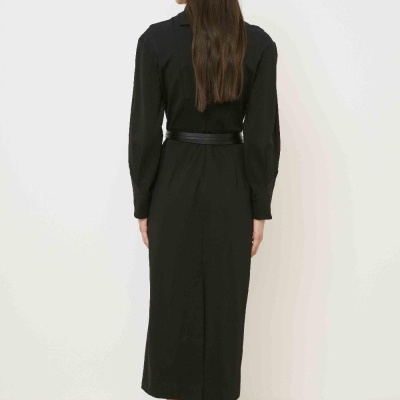 Vestido midi preto com cinto usado por mulher vista de costas