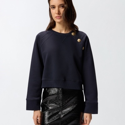 Sweatshirt azul escuro com botões dourados no ombro e saia preta brilhante
