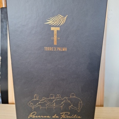 Caixa preta de papelão rígido com gravação dourada Torres de Palma e desenho de cinco pessoas abraçadas