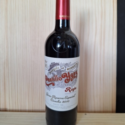 Garrafa de vinho tinto com rótulo Castillo Ygay Rioja 2010 em madeira clara