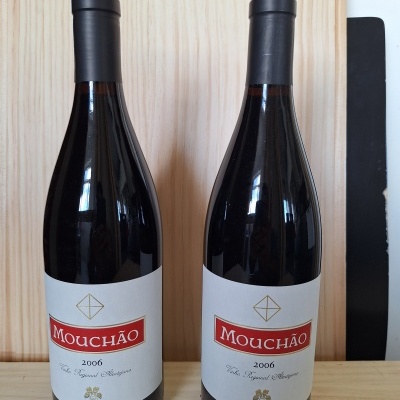 Duas garrafas de vinho Mouchão 2006 sobre madeira clara