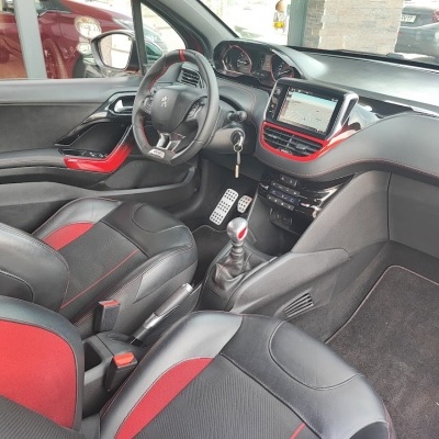 Interior de carro com bancos pretos e vermelhos e painel com ecrã táctil