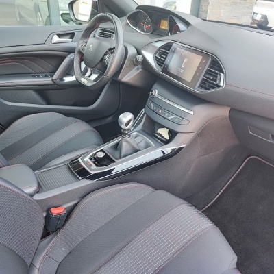 Interior de carro com bancos em tecido preto e detalhes vermelhos